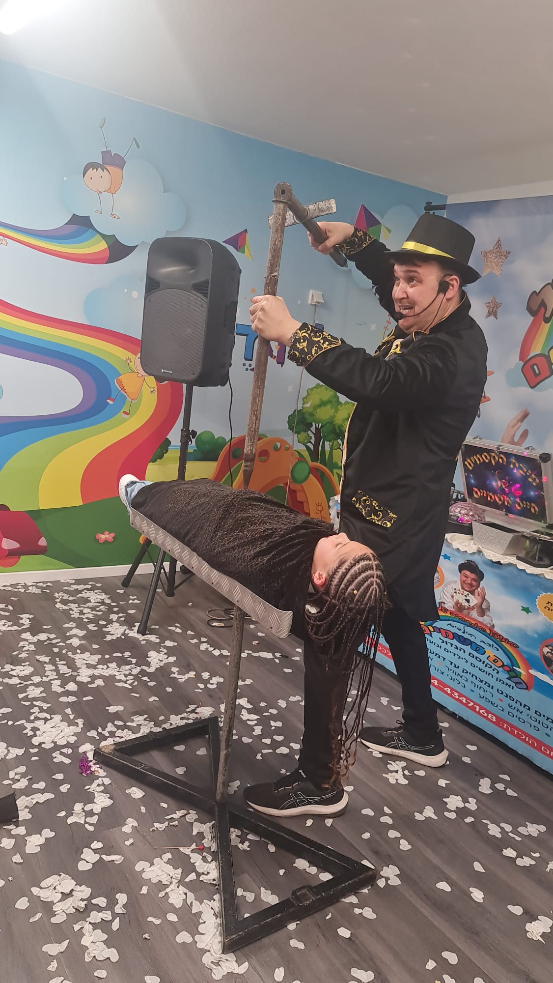 קוסם חיים מחזיק בלוני צורות מול קהל ילדים